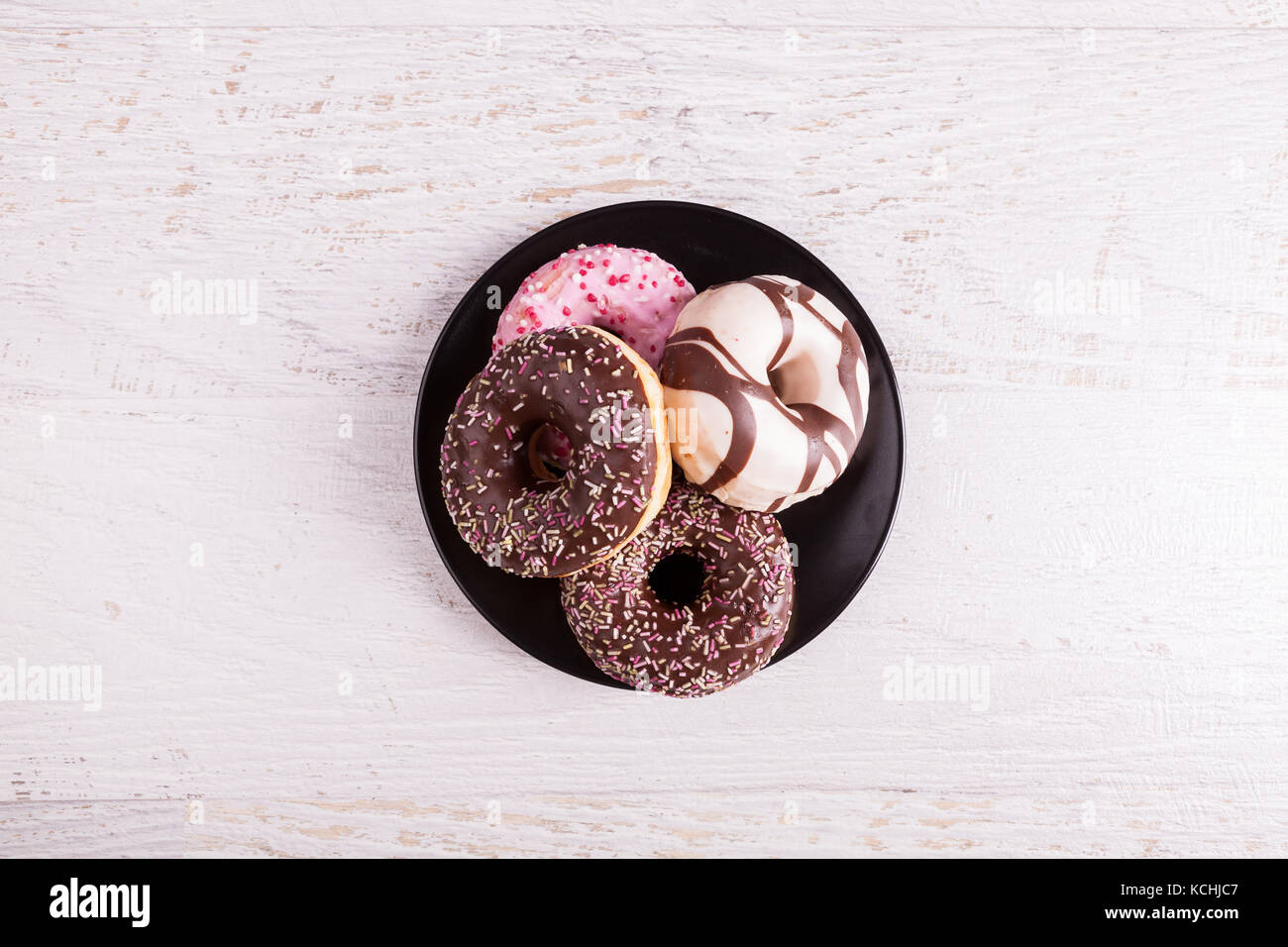 Different type of donuts on white wooden background Stock Photo - Alamy