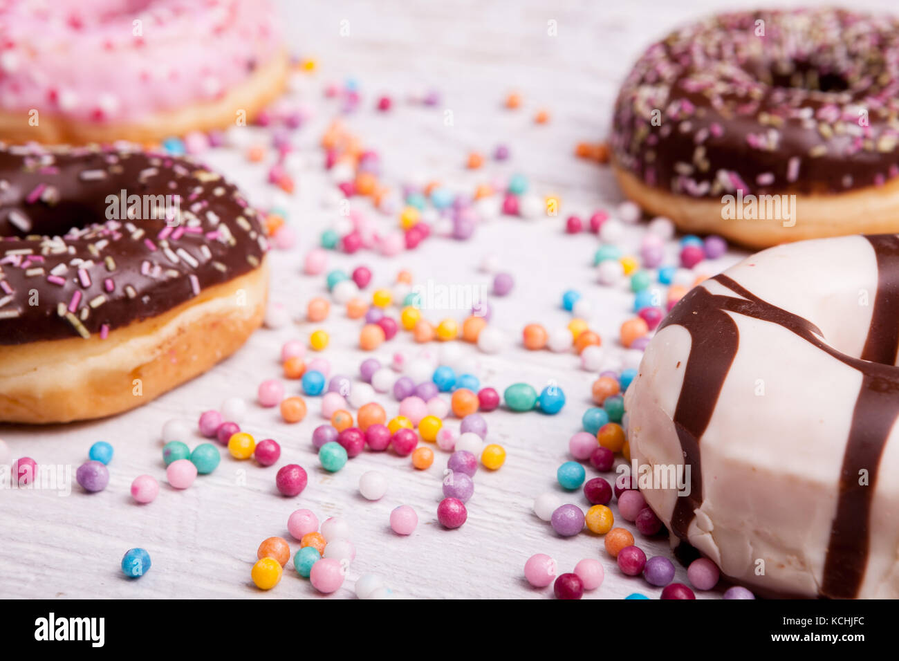 Different type of donuts on white wooden background Stock Photo - Alamy