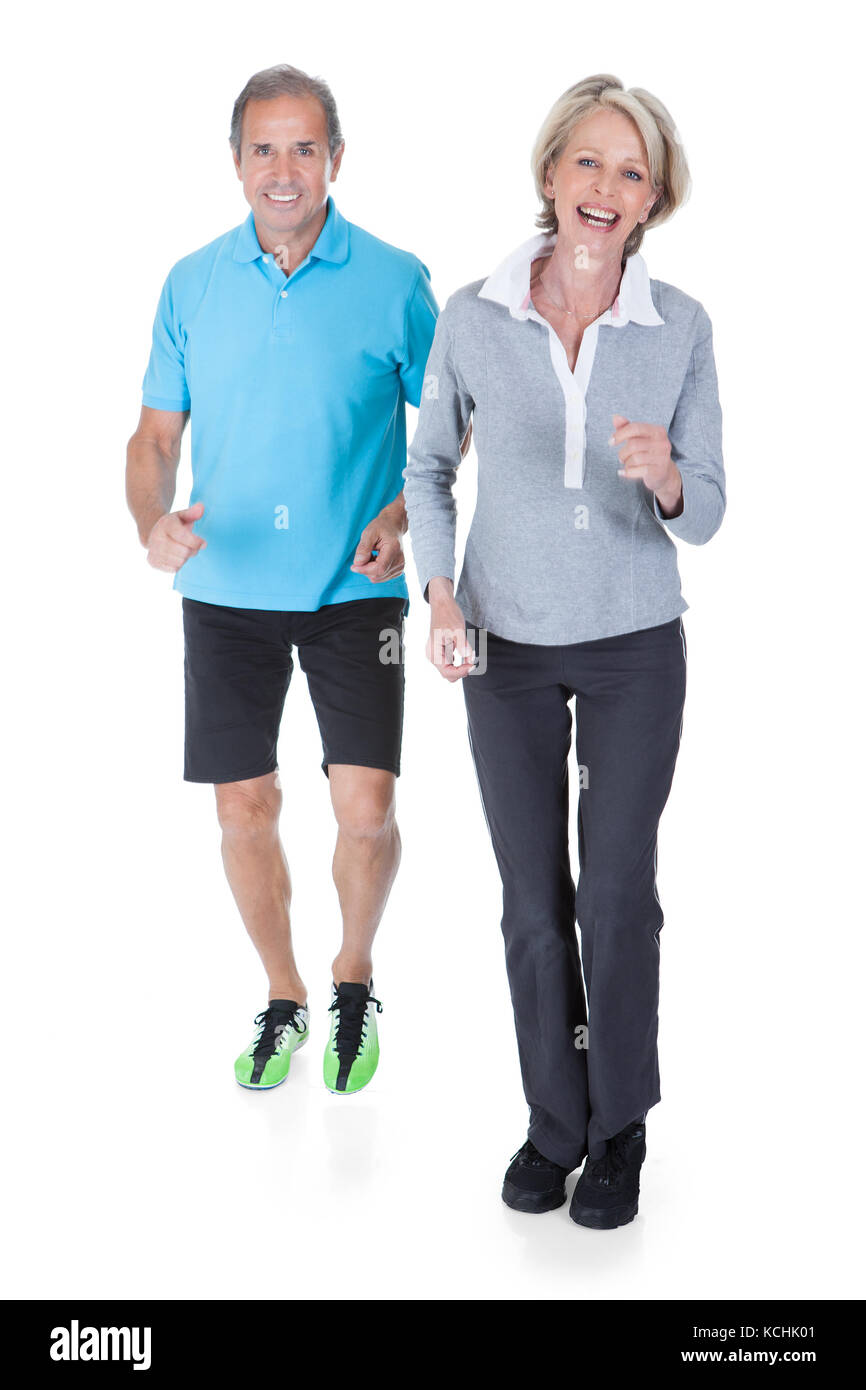 Happy Mature Couple Jogging Over White Background Stock Photo