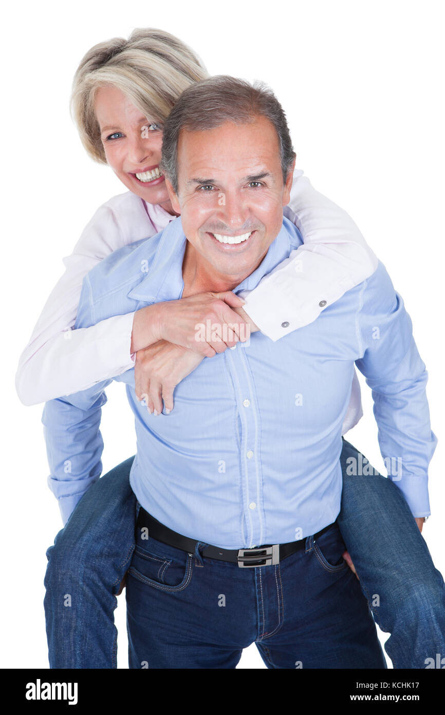 Mature Man Piggybacking His Happy Wife Over White Background Stock Photo