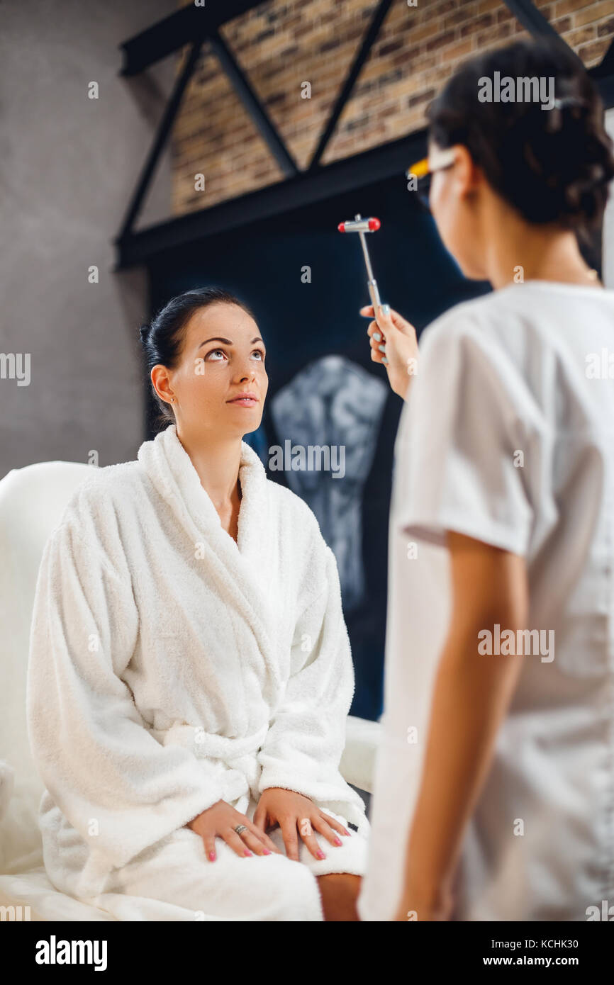 Doctor checking reflexes of his patient with reflex hammer Stock Photo