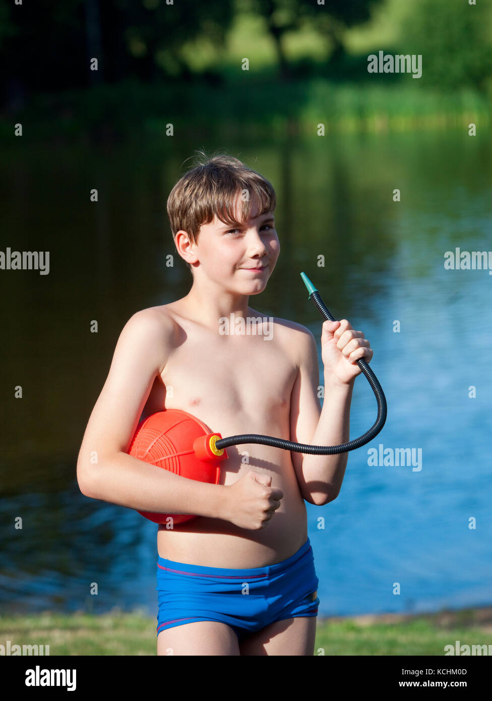 Portrait of a Boy Playing with a Foot Air Pump Outdoors Stock Photo