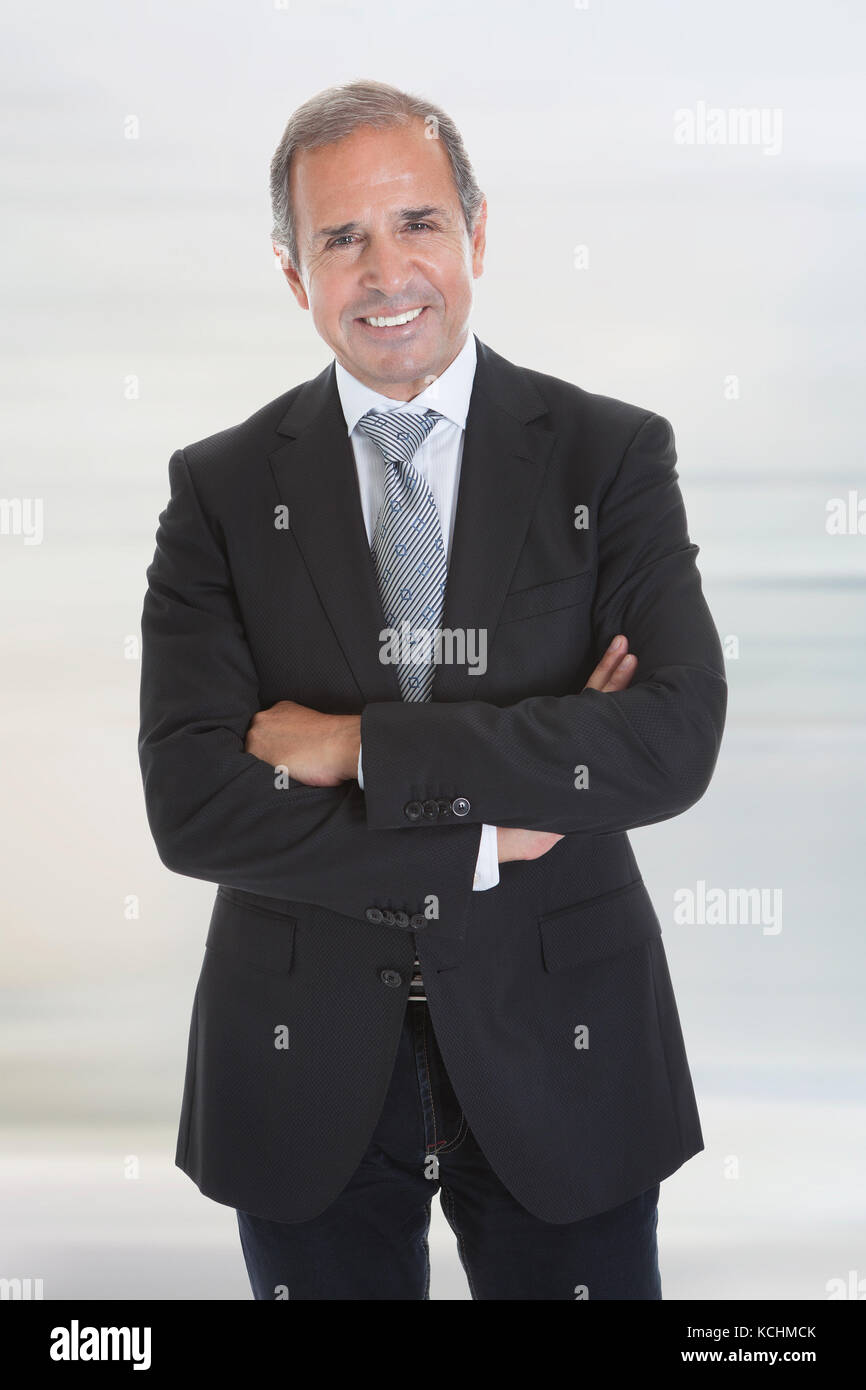 Portrait Of Happy Businessman Standing With Arm Crossed Stock Photo - Alamy