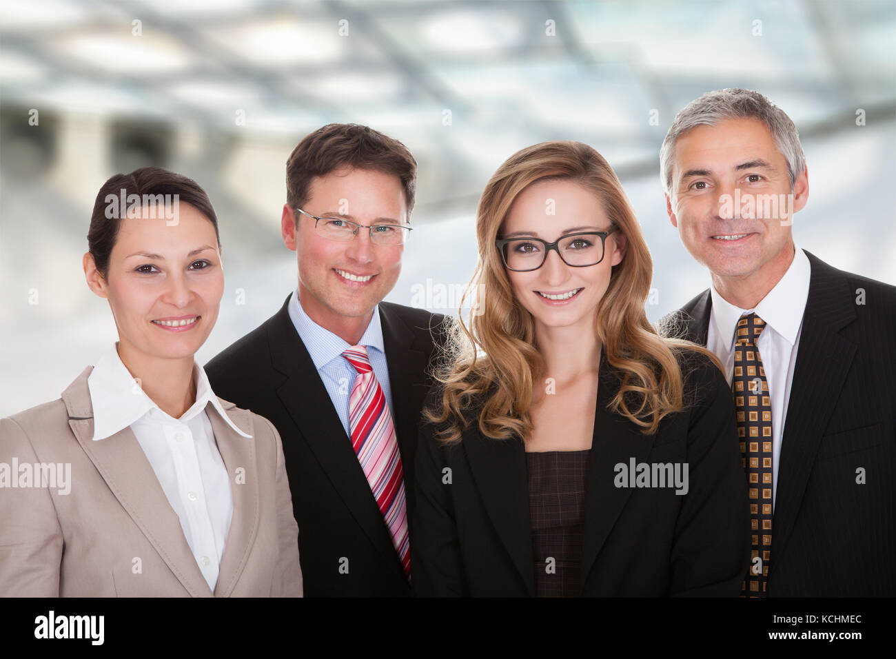 Smiling group of stylish business professionals standing in a row with their arms folded Stock Photo