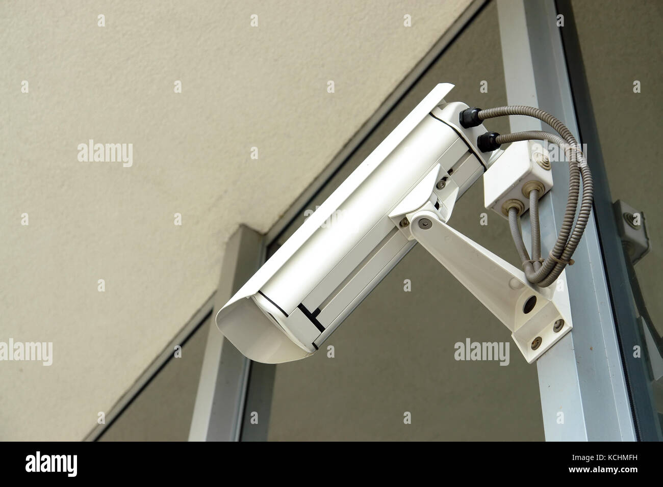 Security cctv camera fixed to office window frame Stock Photo