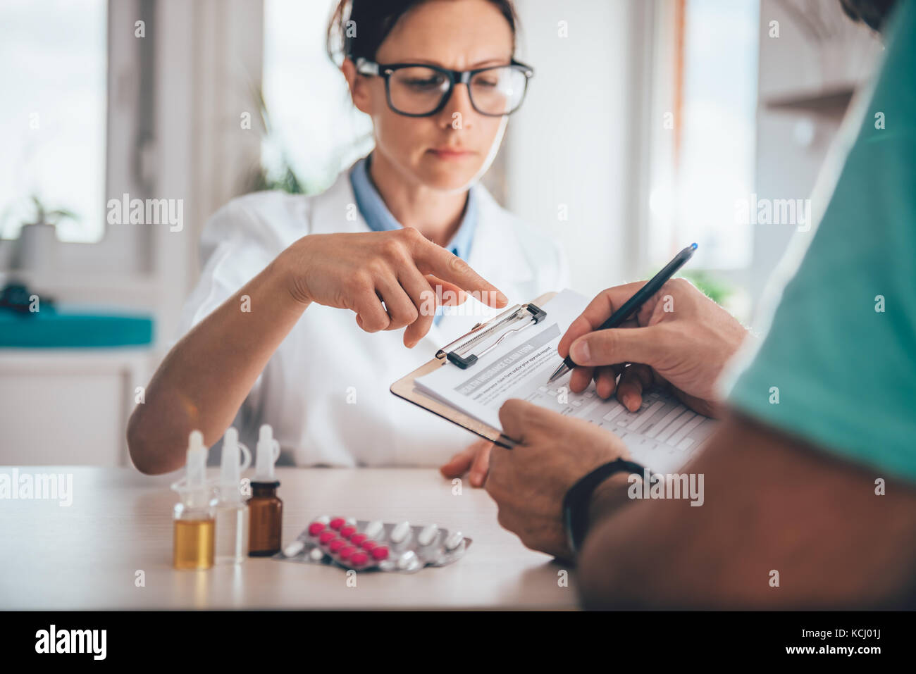 Patient filing health insurance claim form in the doctors office Stock