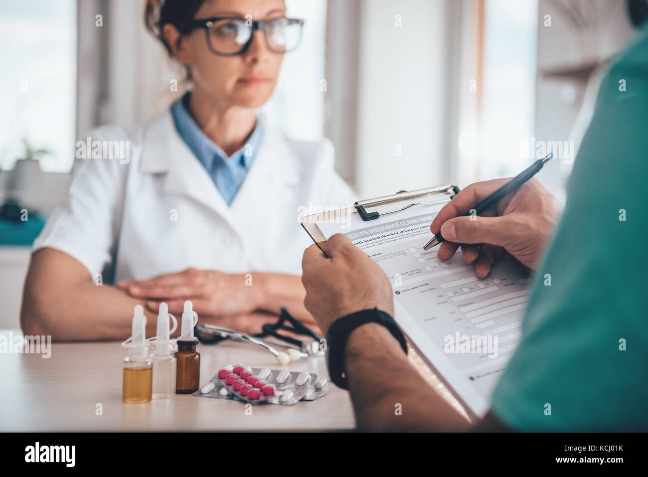 Patient filing health insurance claim form in the doctors office Stock