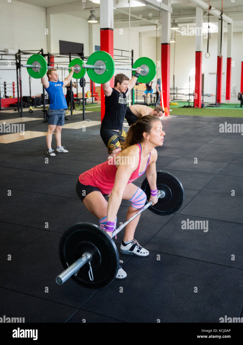 Determined Athletes Lifting Barbells In Gym Stock Photo Alamy