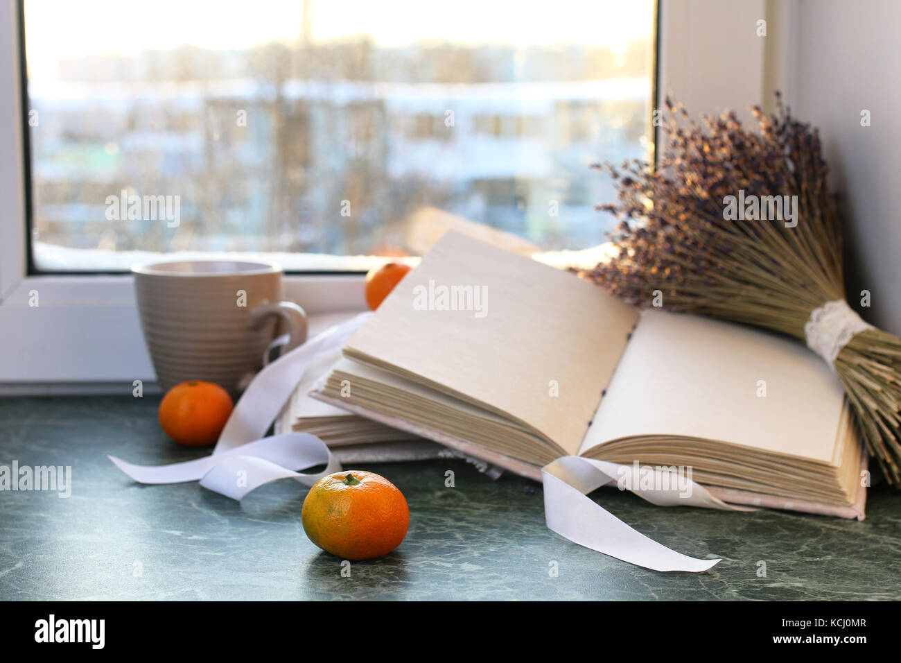 tangerines and vintage books on a marble table by the window Stock