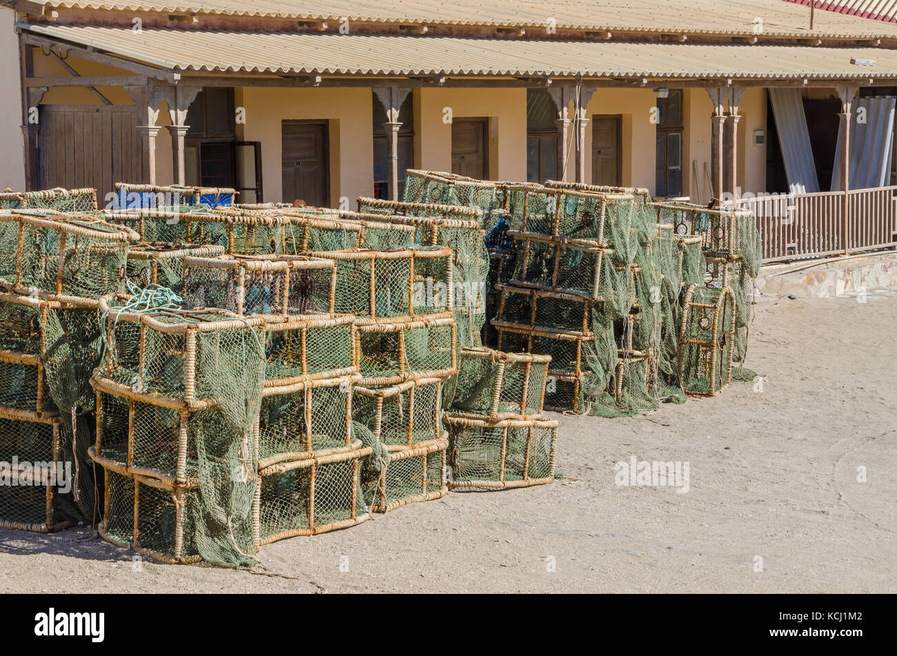Many lobster or crayfish traps stacked in front of old building, Luderitz, Namibia, Southern Africa Stock Photo