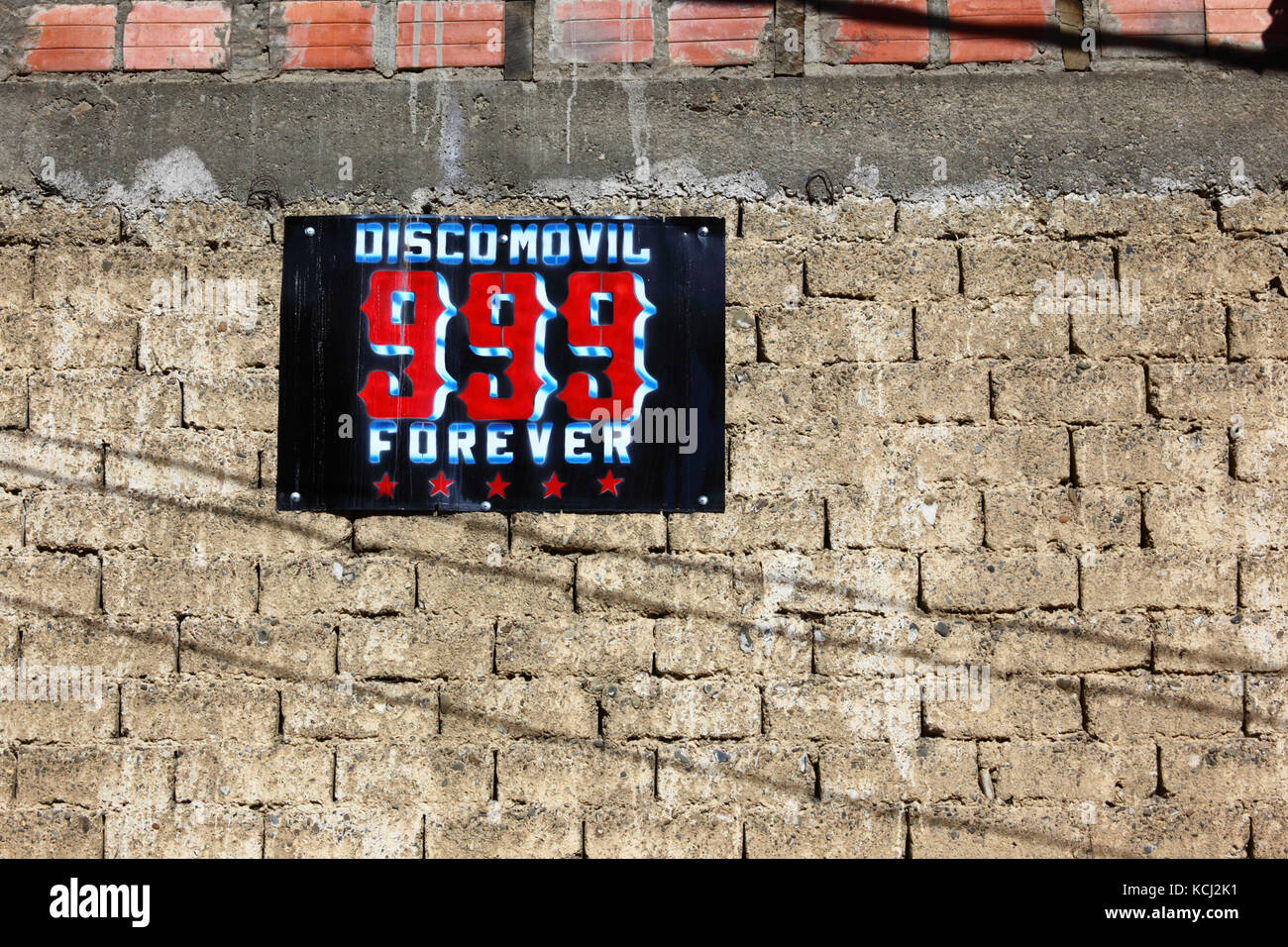 Mobile Disco 999 Forever sign on brick and adobe / mudbrick wall, El Alto, Bolivia Stock Photo