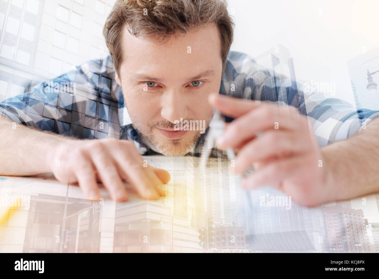 Attentive engineer using compasses Stock Photo - Alamy