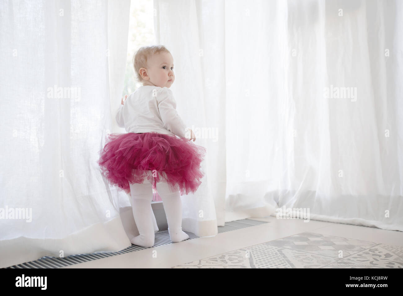 Cute child at window in tutu on a white background Stock Photo