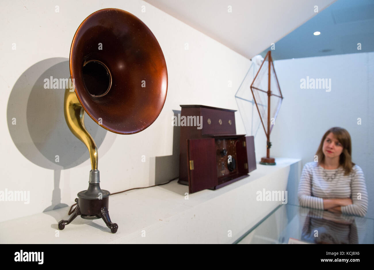 A visitor views (left to right) a 1925 Radiolux Amplion loudspeaker, a 1922 Gilbert & Co radio receiver and a 1920's Radion loop antenna, part of Listen: 140 Years of Recorded Sound, at the British Library in London. Stock Photo