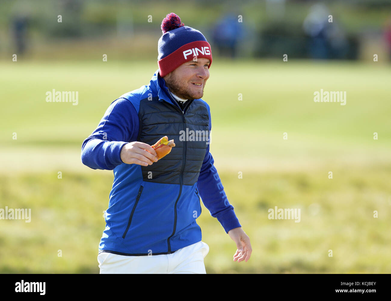 England's Tyrrell Hatton eats a hot dog during day one of the Alfred Dunhill Links Championship at St Andrews. Stock Photo