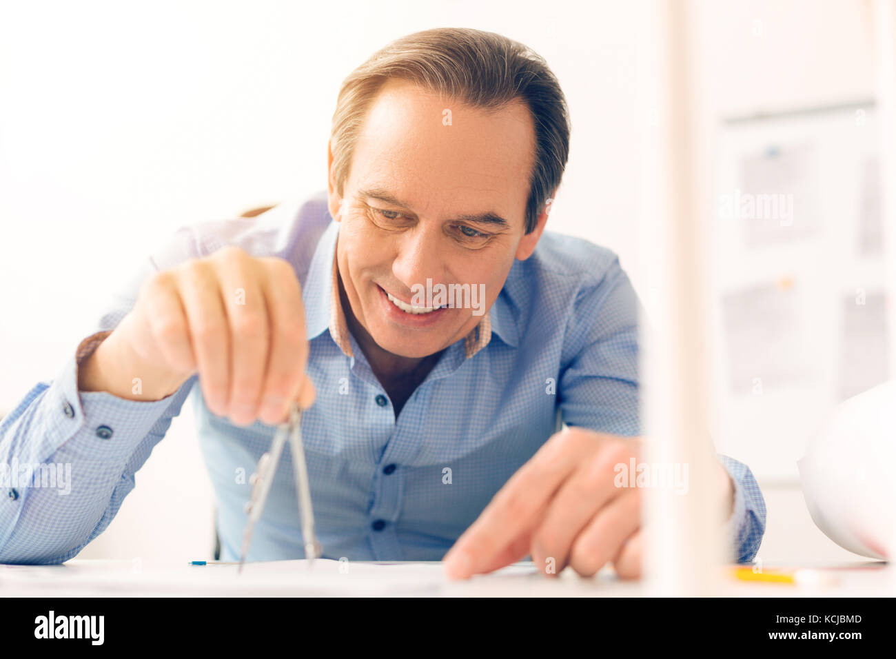 Professional male engineer holding a pair of compasses Stock Photo - Alamy