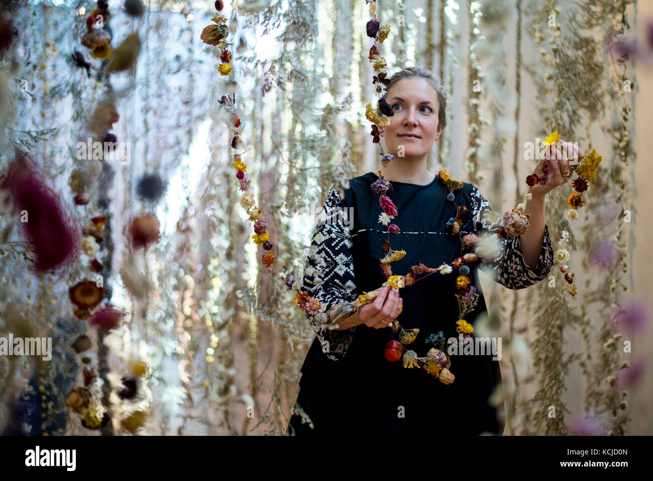 Artist Rebecca Louise Law puts the finishing touches to her new hanging installation 'Life in Death' featuring 375,000 flowers, at the Shirley Sherwood Gallery of Botanical Art, part of Artful Autumn at Kew Gardens in south west London. Stock Photo