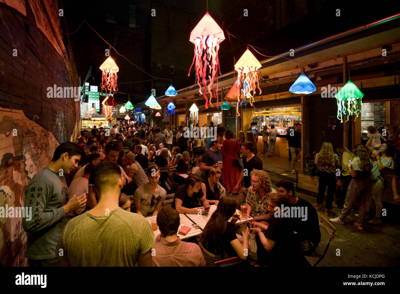 Typical night time scene in the Kuplung ruin bar pub in budapest with people drinking sitting standing talking .... Stock Photo