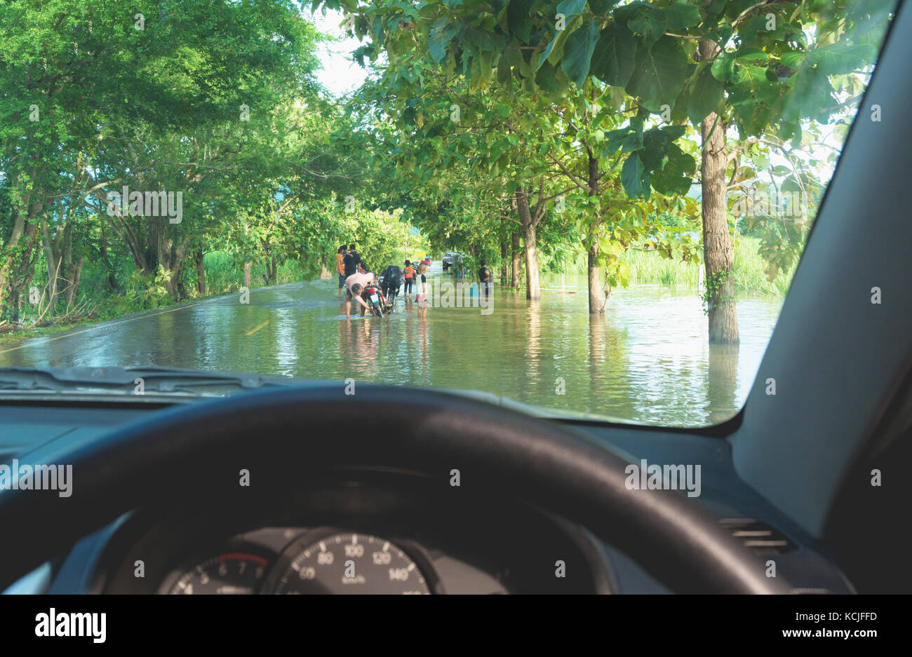 Car driving in heavy rain on a flooded road. Car through flood water