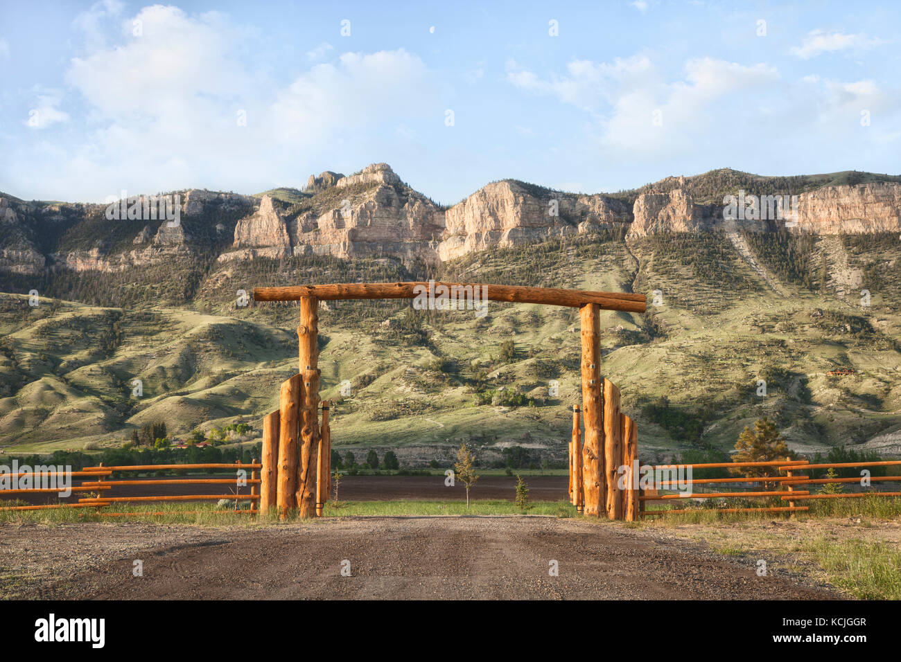 A wooden ranch gate in front of rocky cliffs in Wyoming, USA Stock Photo