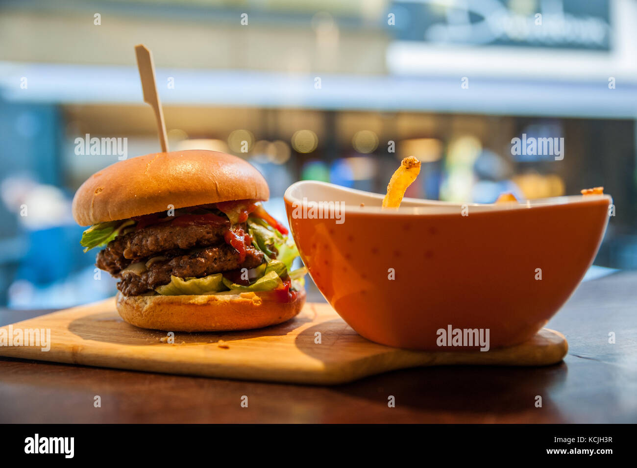 Delicious burger and french fries on the wooden chopping board Stock Photo