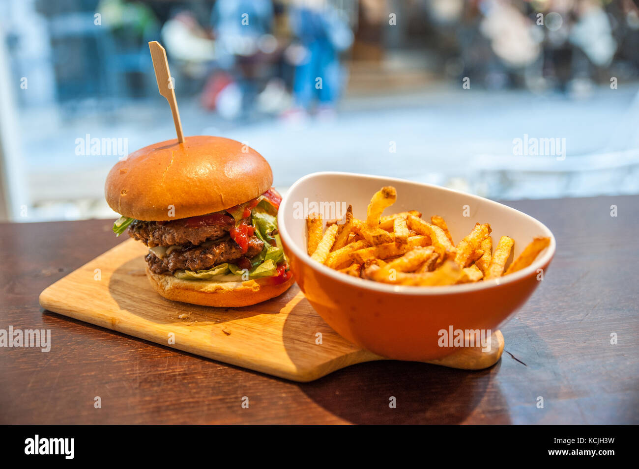 Delicious burger and french fries on the wooden chopping board Stock Photo