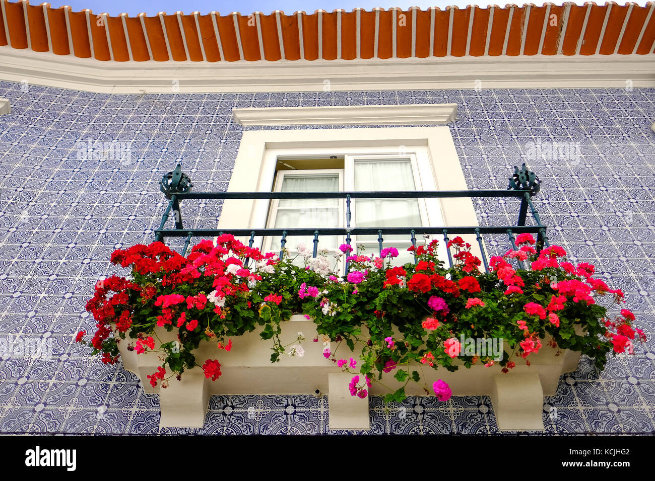 window with balcony ornate with flowers in a traditional Portuguese style residence in Aveiro. The wall is covered with ceramic tiles Stock Photo