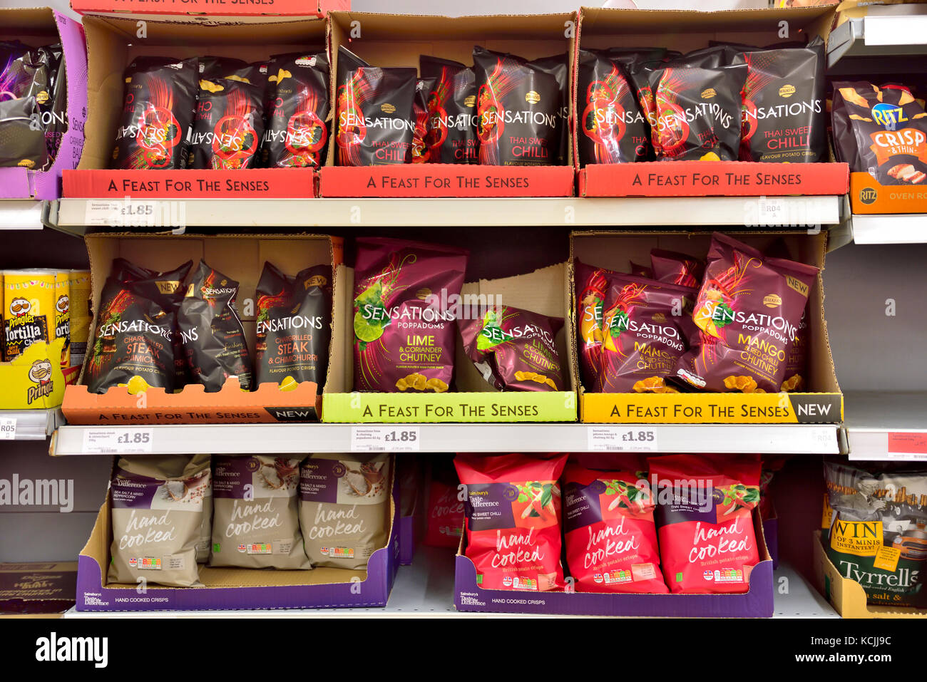 Bags of various spicy tortilla crisps for sale on supermarket shelves Stock Photo