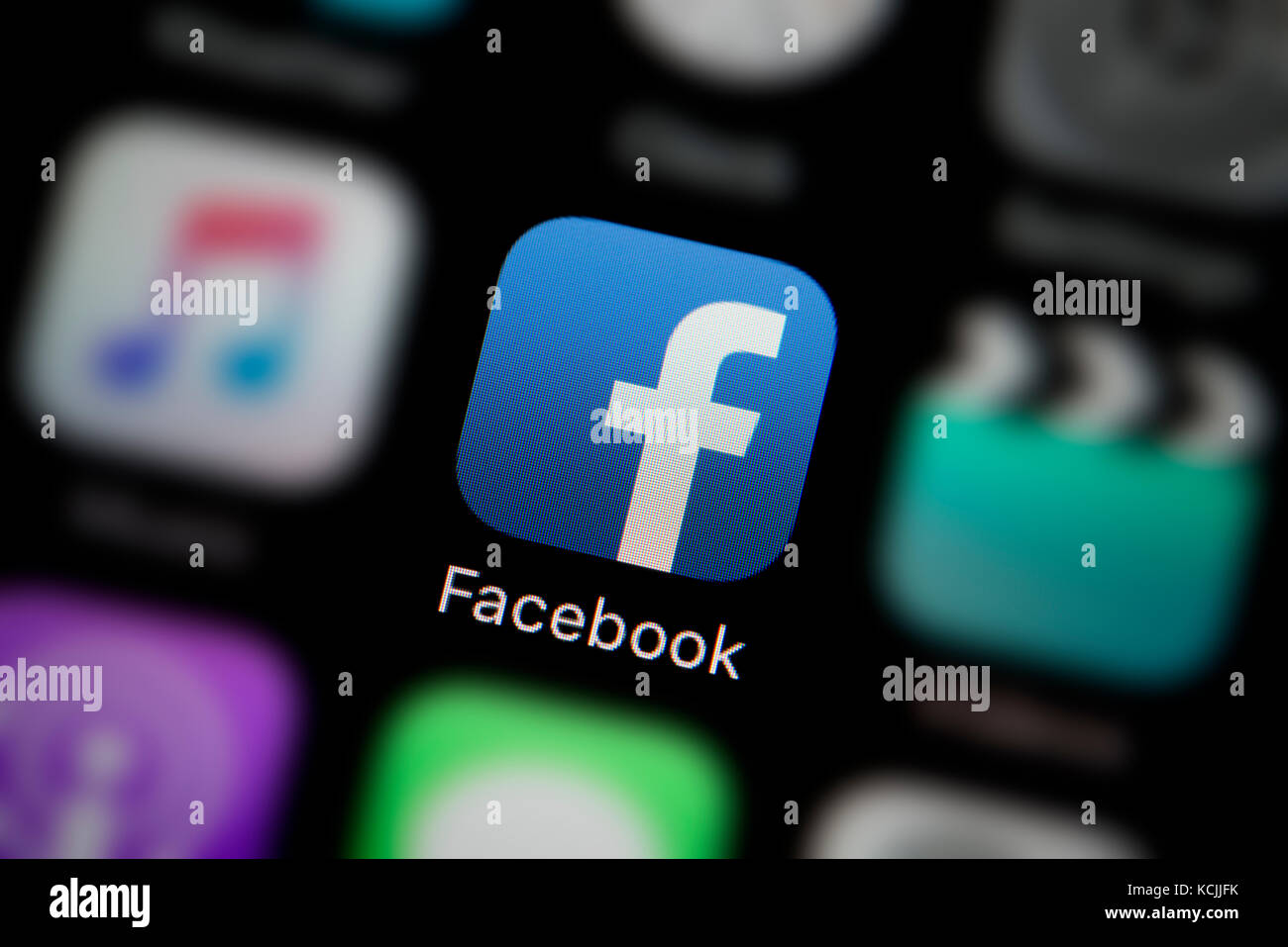 A close-up shot of the company logo representing the Facebook app icon, as seen on the screen of a smart phone (Editorial use only) Stock Photo