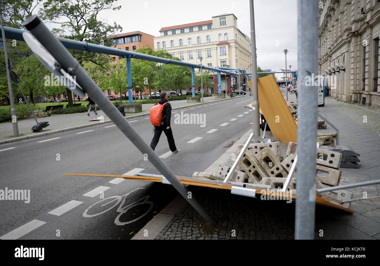 Berlin, Germany. 5th Oct, 2017. A pedestrian walks past a toppled over construction fence in Berlin, Germany, 5 October 2017. Storm Xavier toppled over many trees and ripped of branches in the capital. Credit: Kay Nietfeld/dpa/Alamy Live News Stock Photo