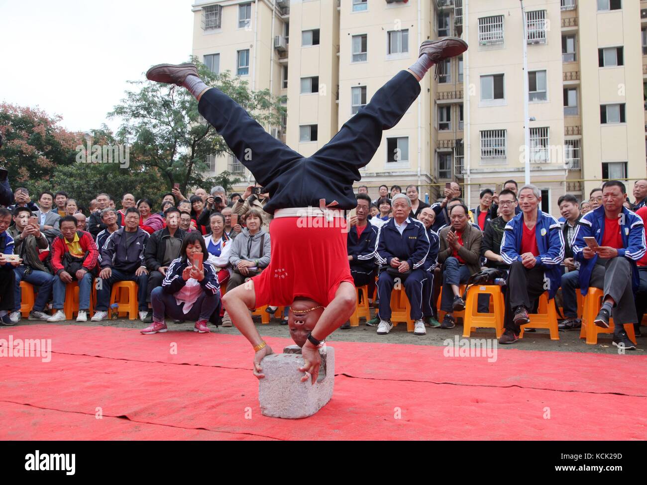 Nanjing, China's Jiangsu Province. 6th Oct, 2017. A contestant stands upside down on a stone lock in a Stone Lock fitness competition in Yinxiang Community of Jiangning District of Nanjing, capital of east China's Jiangsu Province, Oct. 6, 2017. Nearly 400 contestants from 19 teams attended this competition on Friday. Credit: Li Wenbao/Xinhua/Alamy Live News Stock Photo