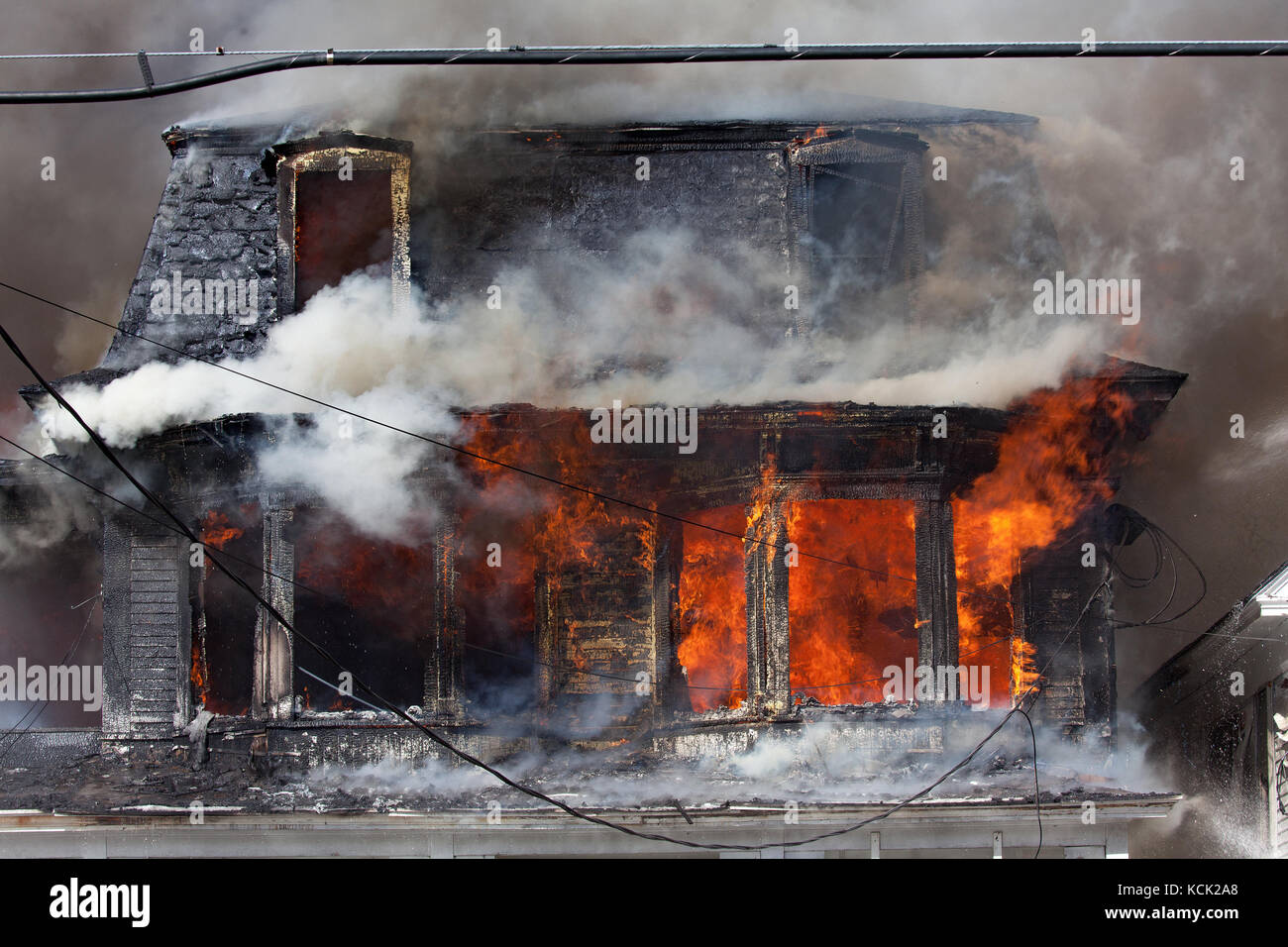 Residential home engulfed in flames. Stock Photo