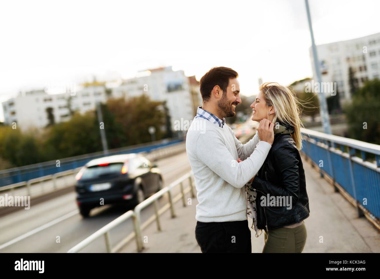 Happy young couple hugging and kissing on bridge Stock Photo - Alamy