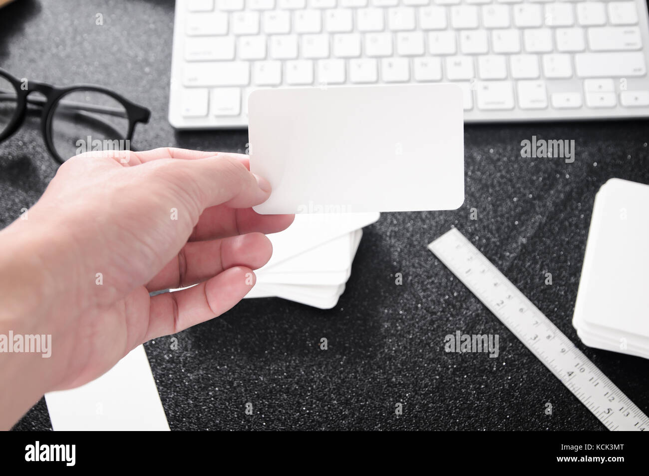 Blank Business Card Mock Up In Hand On Blurre Office Desk