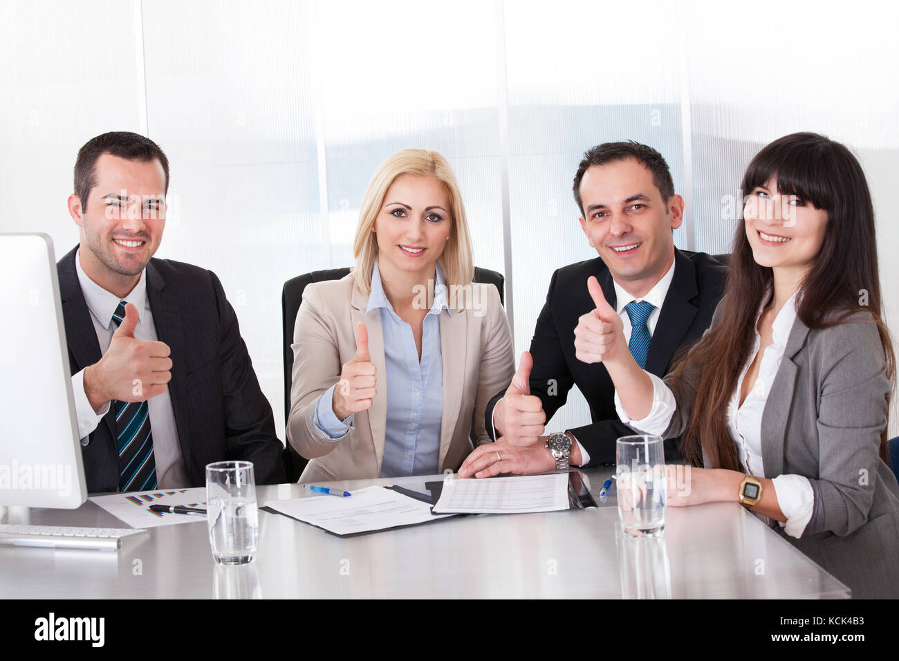 Happy Business Team Showing Thumb Up Sign Stock Photo - Alamy