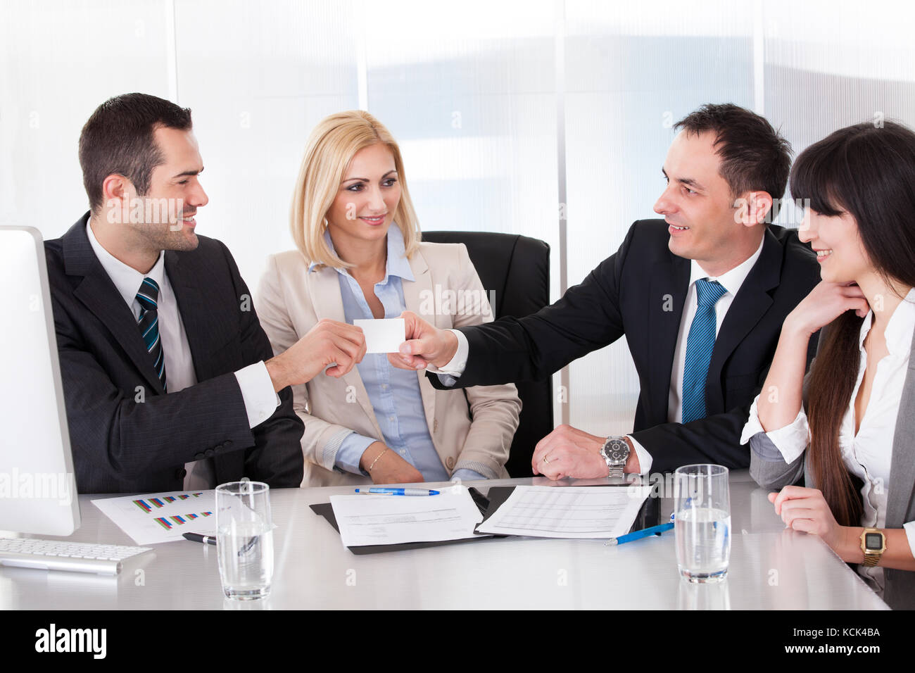 Two Businessman Exchanging Visiting Card In front Of Colleges Stock Photo