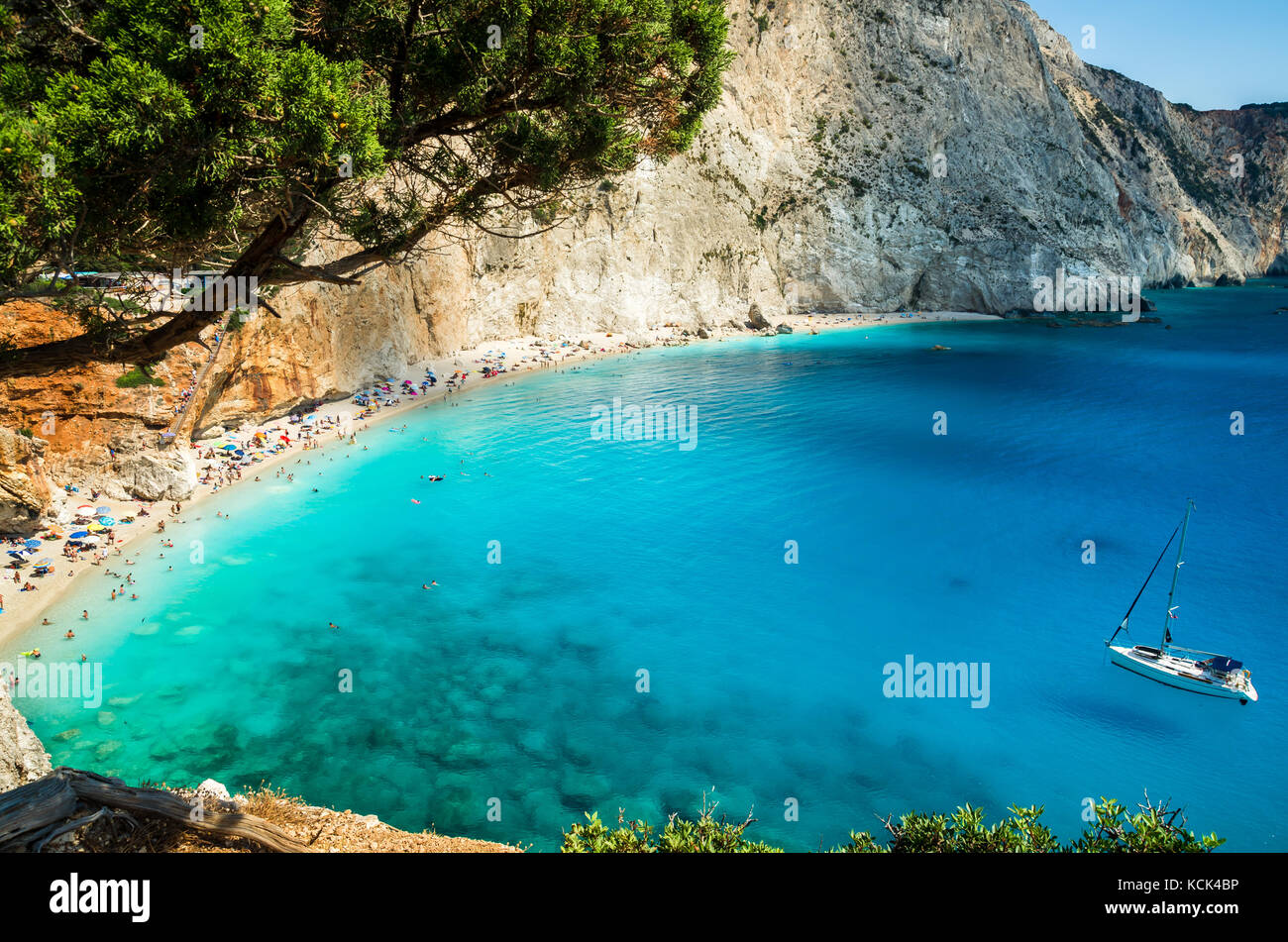 Porto Katsiki beach in Lefkada island, Greece. Beautiful view over the beach. The water is turquoise and there are tourists on the beach and a boat on Stock Photo