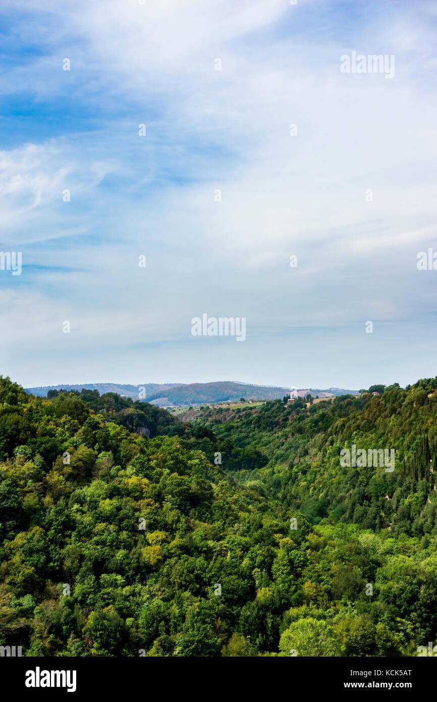 Vertical photo with view into the small valley between two hills or