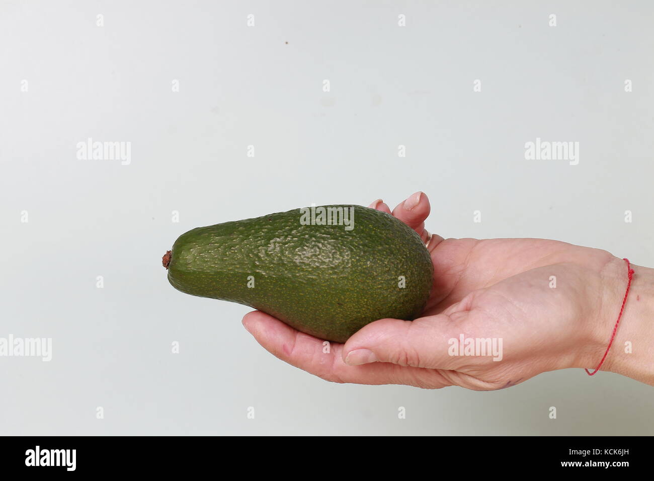 Style minimalism. Ripe avocado in a woman's hand Stock Photo - Alamy