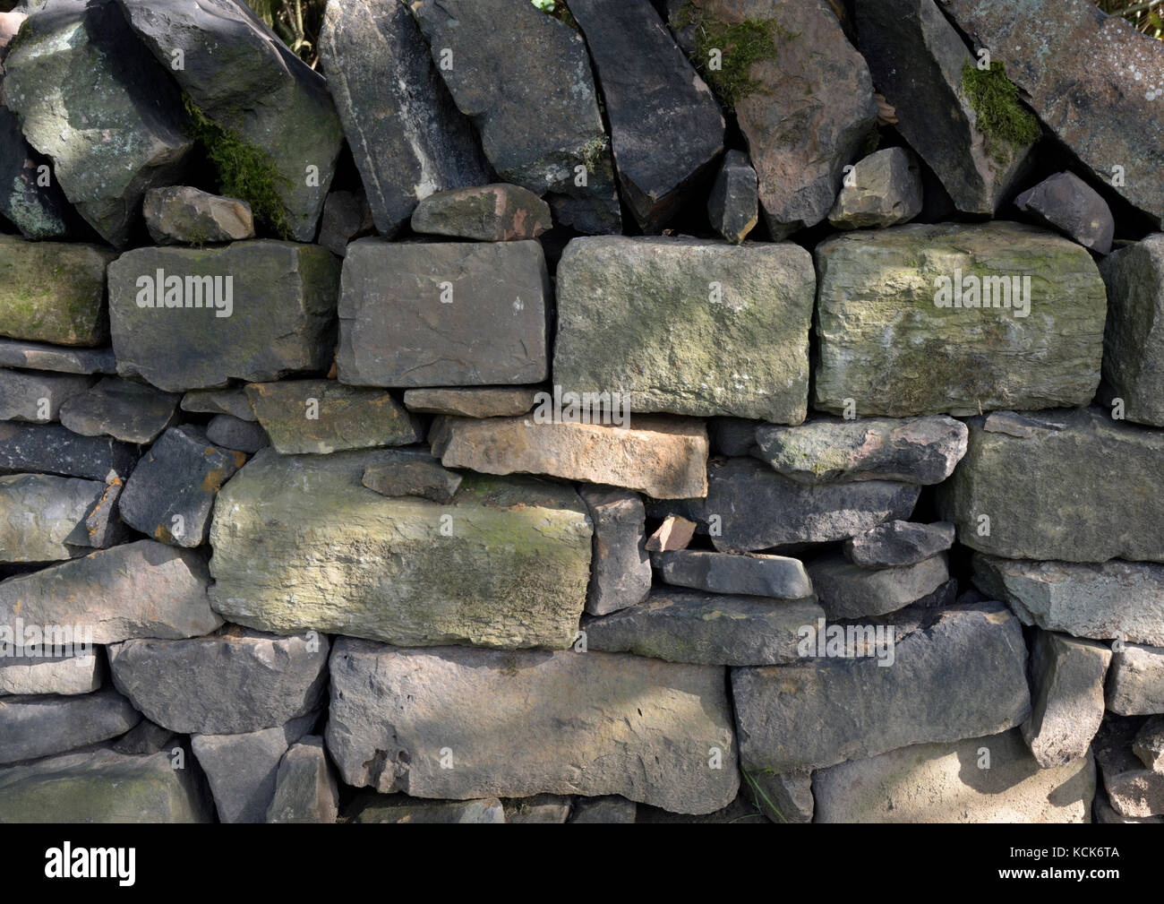 Dry stone wall with dappled sunlight in burrs country park bury lancashire uk Stock Photo