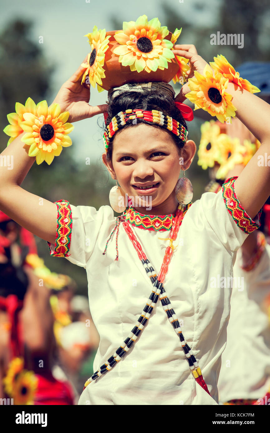 Portrait of beautiful Filipino girl carrying on head at the Baguio flower festival in Philippines. Filipino youngsters wearing ethnic minority costume Stock Photo