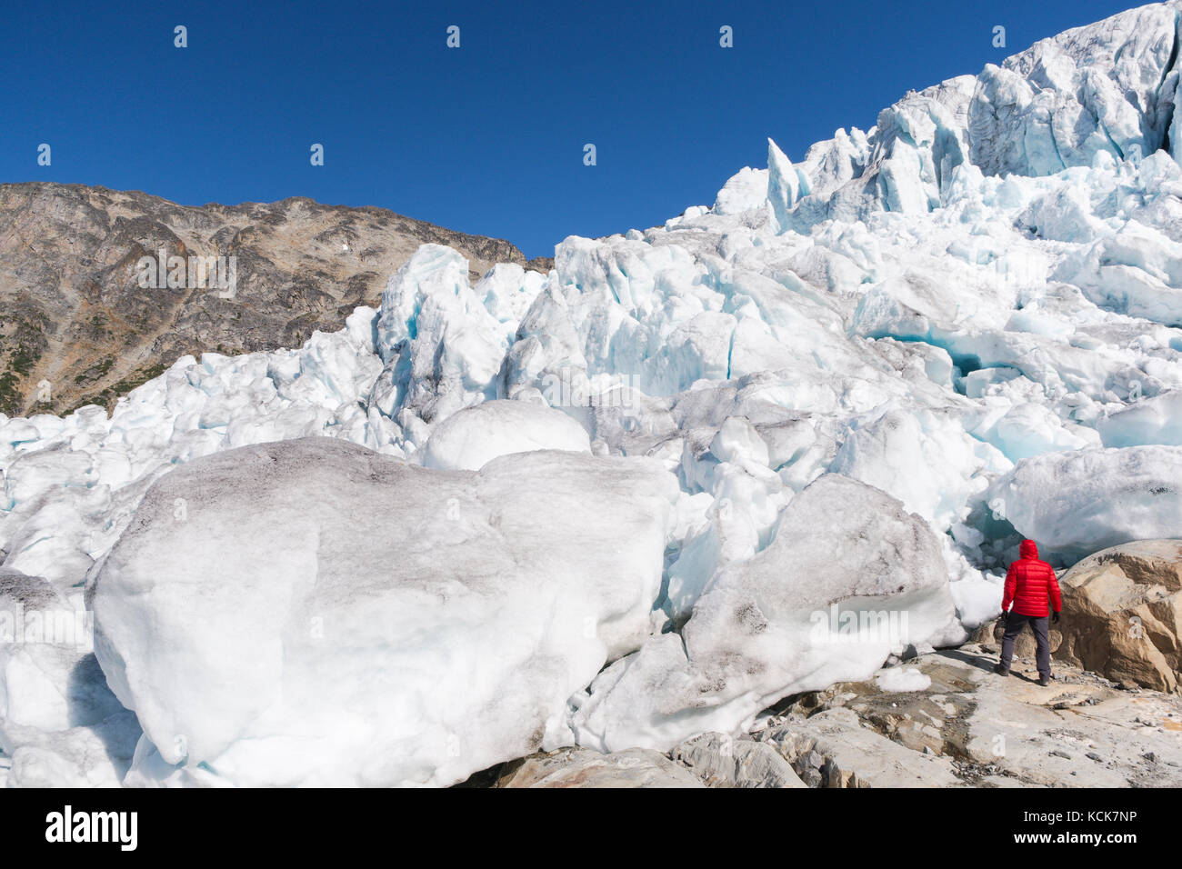 Hiker in front of Matier Glacier in Joffre Lakes provincial park, British Columbia, Canada. Stock Photo