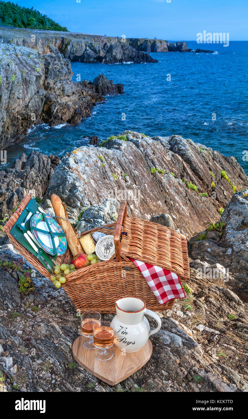 PICNIC FRENCH BRITTANY hamper with typical French wine cheese & bread produce, on rugged southern Brittany coast at Doëlan Finistere Brittany France Stock Photo