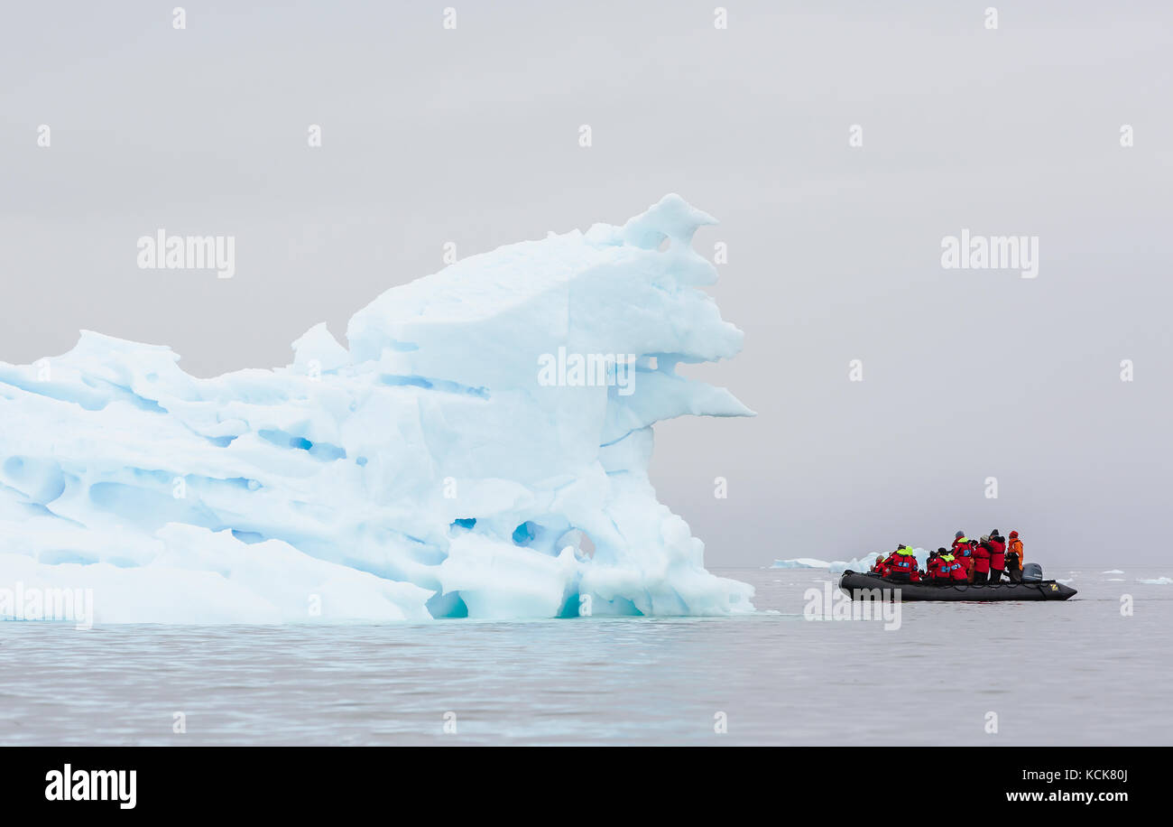 A passenger filled Zodiak cruises amongst ice flows near Pleneau Island, Antarctic Peninsula, Antarctica Stock Photo