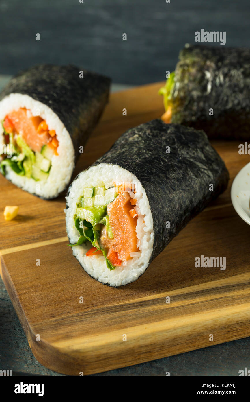 Raw Homemade Salmon Sushi Burrito with Seaweed Cucumber and Carrots Stock Photo
