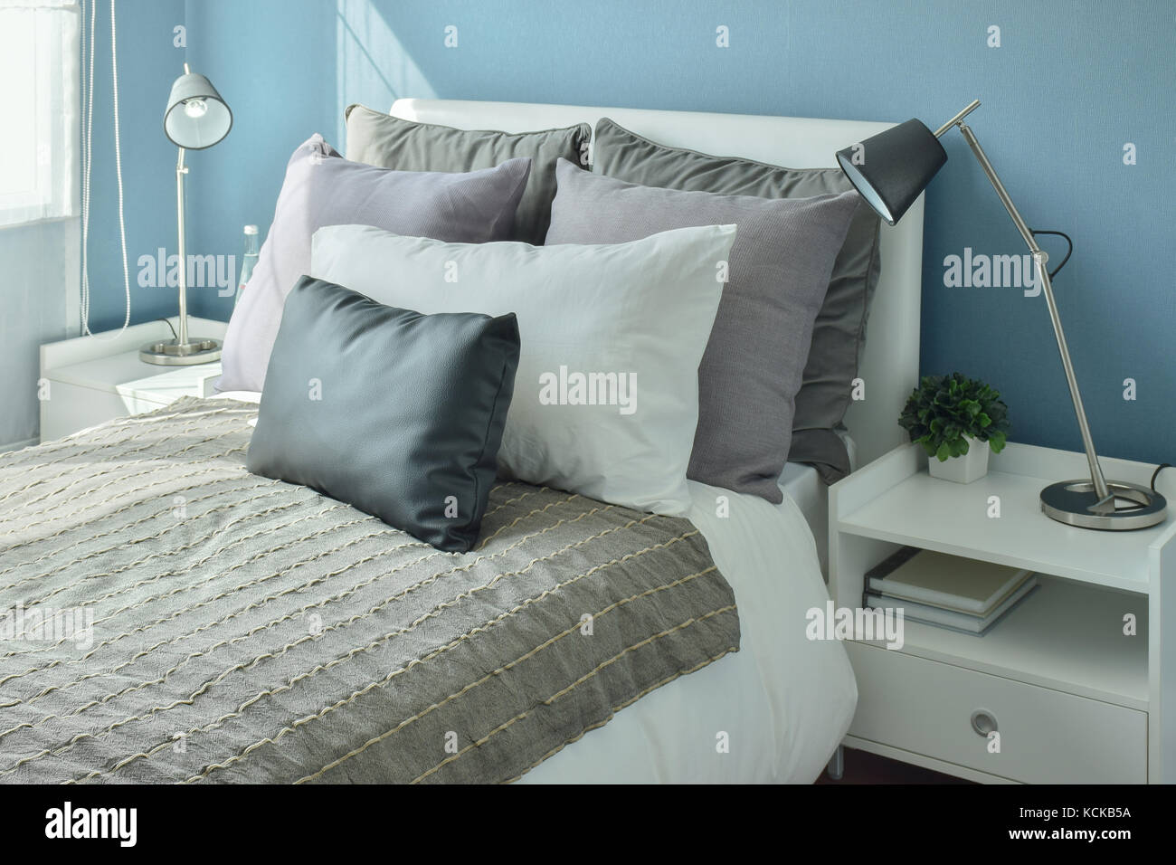 Gray Dark Gray And Beige Pillows On Bed With Blue Wall