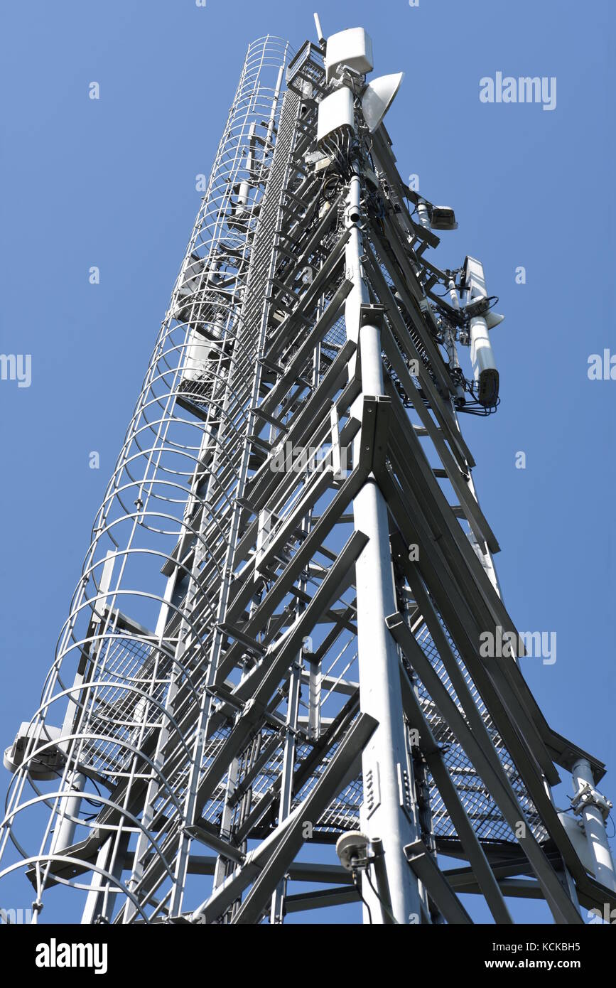 Telecommunications tower with antennas against blue sky Stock Photo