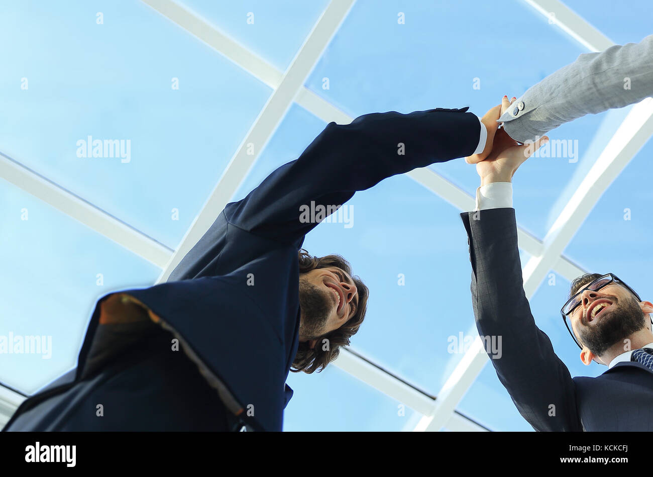 Happy business team giving high five in office Stock Photo - Alamy