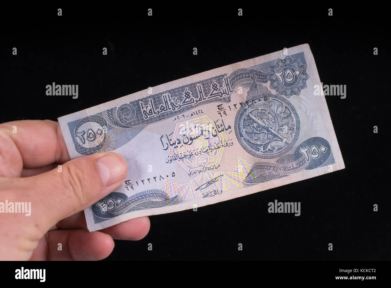 An old Iraqi banknote on the hand Stock Photo