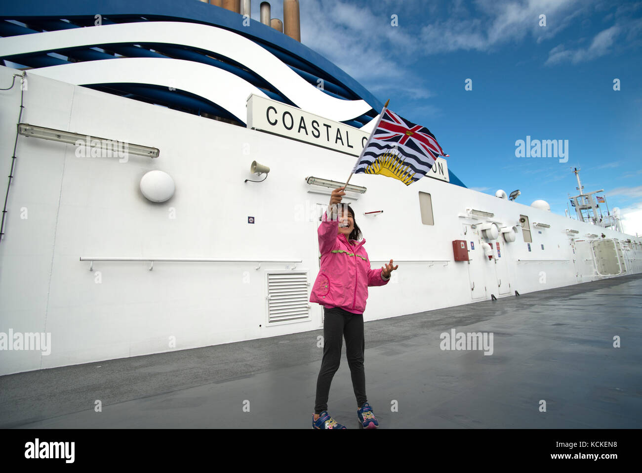 Girl waving British Columbia flag on the Coastal Inspiration of BC Ferries, Salish Sea, British Columbia, Canada Stock Photo